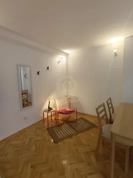 Dnevna soba sa drvenim parketom, foteljom i trpezarijskim stolom. - image 3