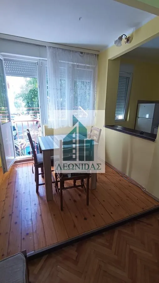 Dining area with a table and chairs next to the balcony doors.