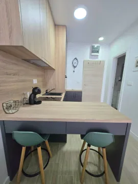 Moderna kuhinja sa šankom i drvenim elementima. - image 3
