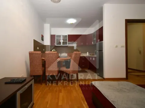 Kuhinja sa trpezarijom i tamnim drvenim elementima. - image 4