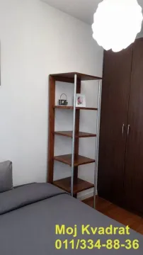 Spavaća soba sa krevetom, drvenom policom i garderoberom. - image 6