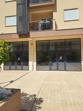 Exterior of a ground-floor commercial space in a building with a paved plateau in front. - image 2