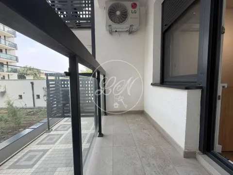 View of a spacious balcony with a glass railing and an air conditioning unit on the wall. - image 14