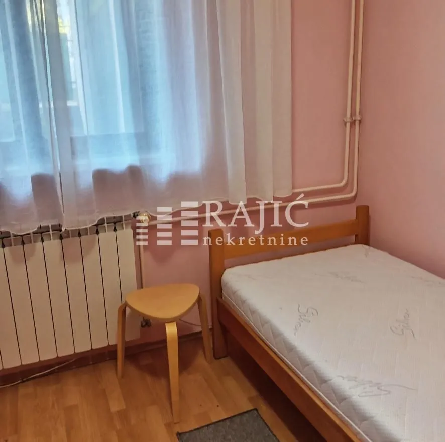 Smaller bedroom with a bed and a window.