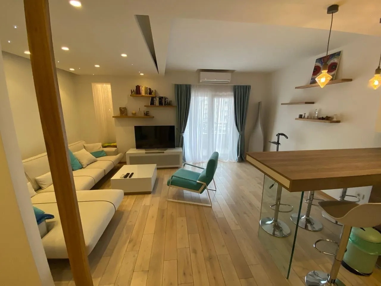 Svijetla dnevna soba sa modernim namještajem i šankom.