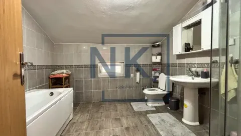 Bathroom equipped with a bathtub, washbasin, and toilet. - image 19