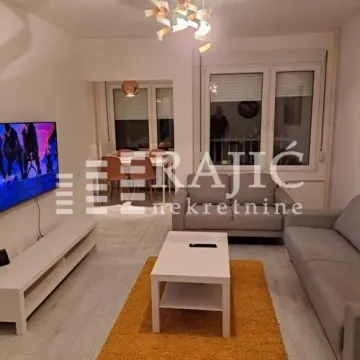 Living room with sofa, TV, and dining area in the background. - image 4