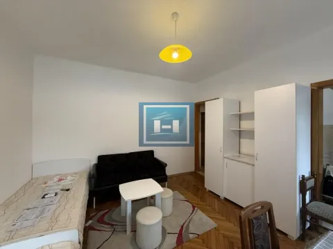 Small bedroom with a bed, sofa, wardrobe, and parquet flooring. - image 6