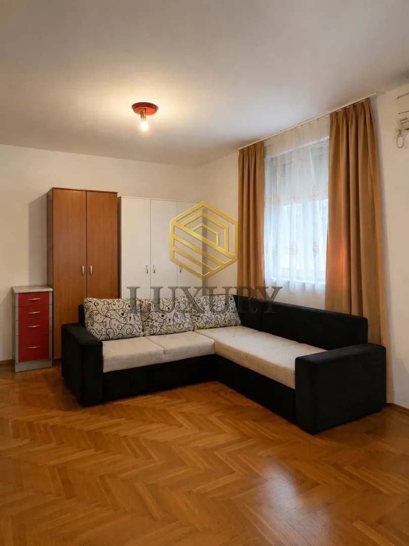Living room with a sectional sofa, closets, and parquet flooring.