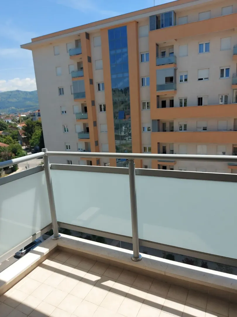 Balkon sa ogradom i pogledom na susjednu stambenu zgradu.