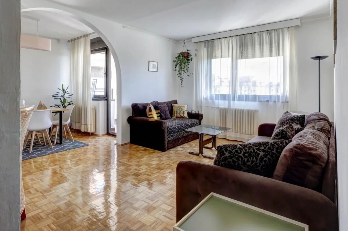 Living room with a sofa set and a dining area beyond.