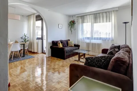 Living room with a sofa set and a dining area beyond. - image 2