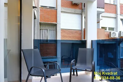 Natkriveni balkon sa dve crne stolice i staklenom ogradom. - image 12
