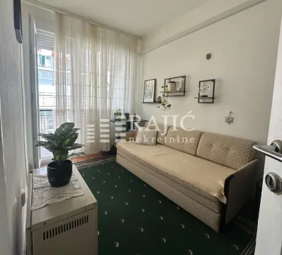 Living room with a seating sofa, green carpet, and access to the balcony. - image 3