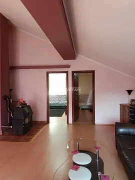 Living room with a sofa, wood stove, and doors leading to other rooms. - image 3