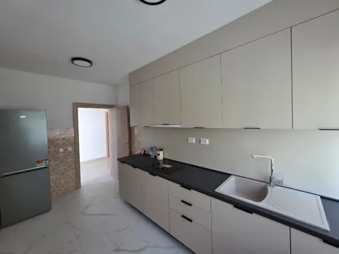 Moderna kuhinja sa bež elementima i ugradnim uređajima. - image 9
