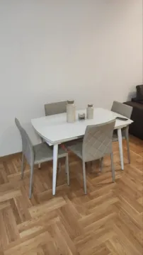 Dining table with four chairs and parquet flooring. - image 5