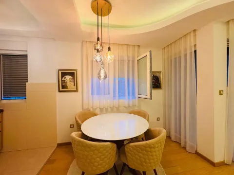 Trpezarija sa okruglim stolom i modernim stolicama ispod viseće lampe. - image 5