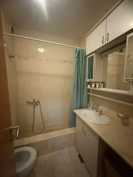 Manje kupatilo sa umivaonikom, ormarićem, ogledalom i tuš kabinom sa zavesom. - image 13