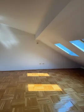 Empty attic room with parquet flooring and skylights. - image 4