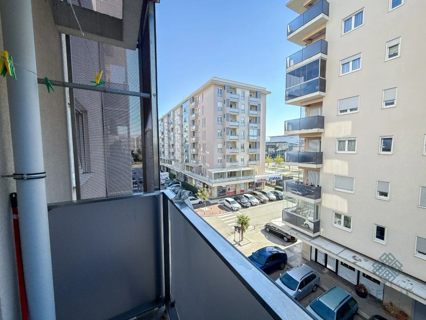 View from the balcony of the city street and surrounding buildings.