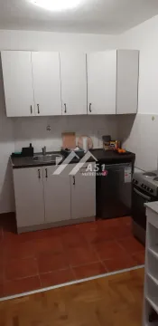 Smaller kitchen with lower and upper cabinets and a stove. - image 3