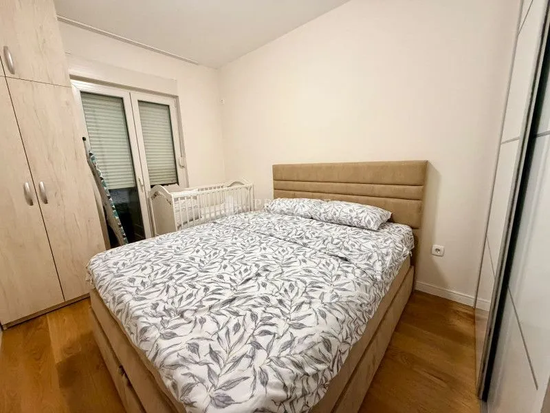 Furnished bedroom with a double bed, wardrobe, and baby crib.