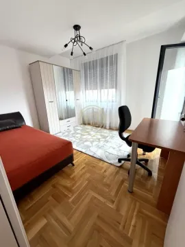 Furnished bedroom with a bed, desk, and wardrobe. - image 9