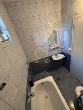 Bathroom equipped with a bathtub, washbasin, mirror, and toilet. - image 10