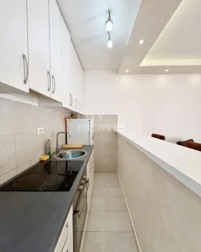 Compact kitchen with built-in appliances and a breakfast bar. - image 5