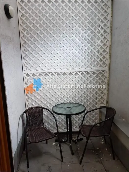 Mali natkriveni balkon sa garniturom za sedenje.