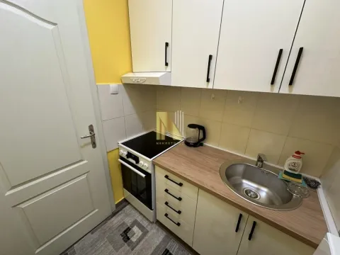 Small kitchen with white cabinets, a stove, and a sink. - image 9