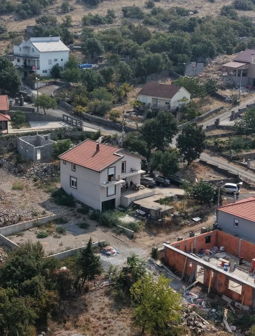 Pogled iz vazduha na porodičnu kuću sa dvorištem u prigradskom naselju.