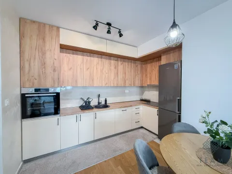 Modern kitchen with wooden elements, built-in oven, and refrigerator. - image 4