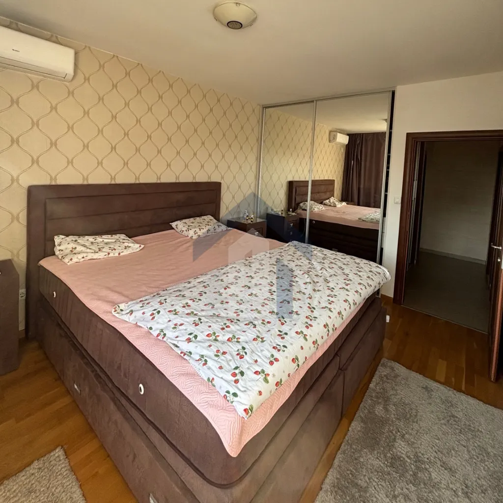 Furnished bedroom with a double bed, wardrobe, and doorway to the hallway.
