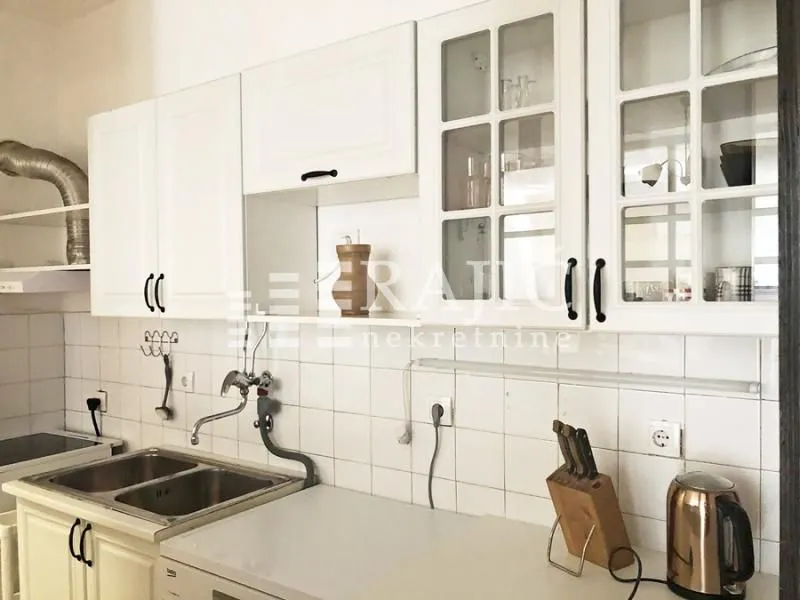 White kitchen with a sink and upper cabinets.
