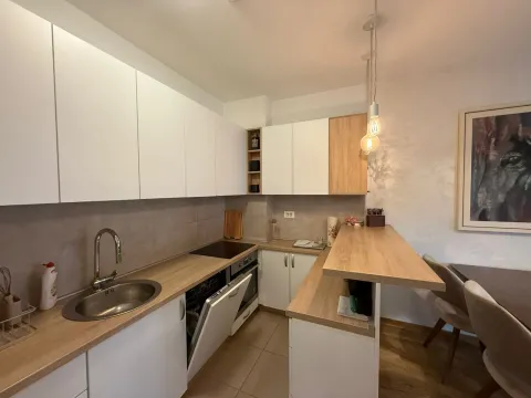 Moderna kuhinja sa bijelim elementima i šankom. - image 13