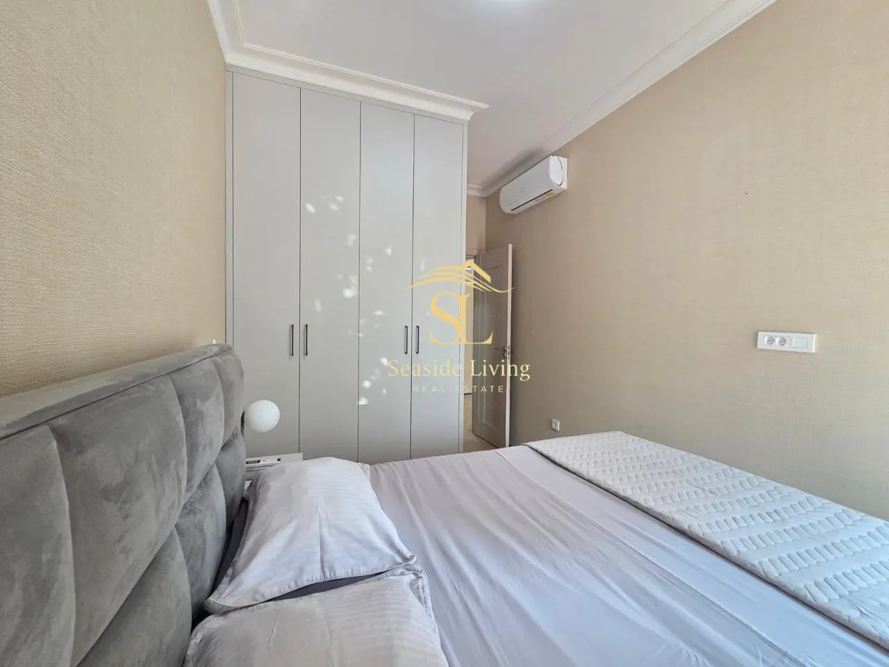 Furnished bedroom with a double bed, wardrobe, and air conditioning.