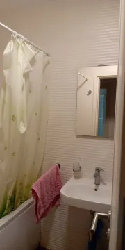 Manje kupatilo sa umivaonikom, ogledalom i kadom sa zavesom za tuširanje. - image 8