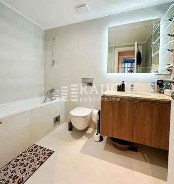 Modern equipped bathroom with a bathtub and a wooden vanity. - image 8