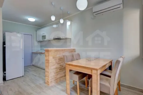 Modern kitchen with a dining area and white cabinets. - image 10