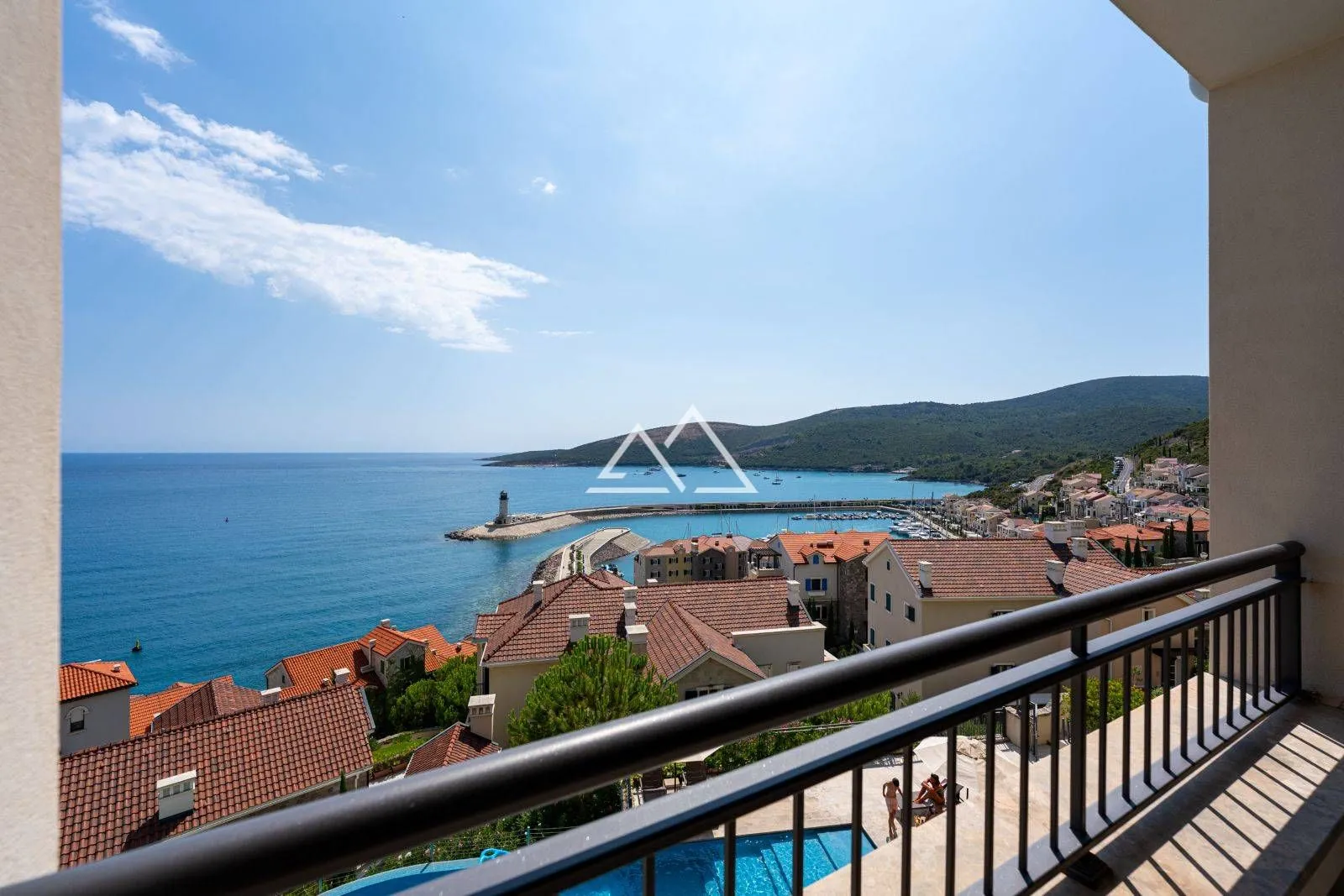 Pogled na more i marinu sa balkona sa ogradom.