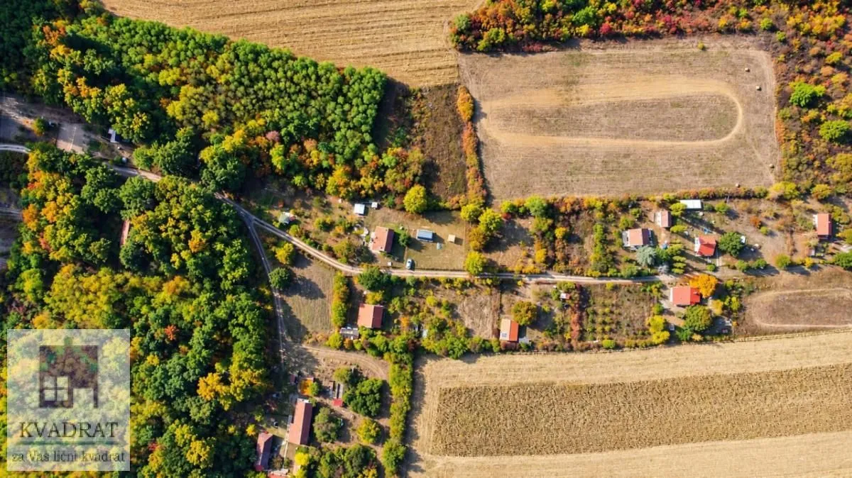 Pogled iz vazduha na seosko imanje okruženo šumom i poljima.
