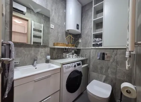 Modernly equipped bathroom with a washbasin, washing machine, and toilet. - image 11