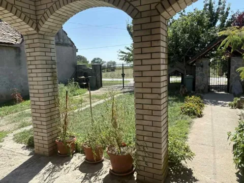 Pogled iz natkrivene terase na dvorište sa ogradom i zelenilom. - image 6