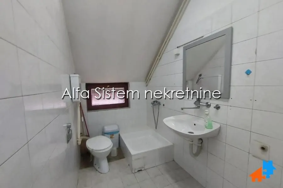 Smaller bathroom with a washbasin, toilet, and shower tray.