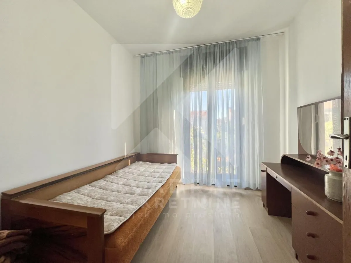 Smaller bedroom with a bed and a desk.