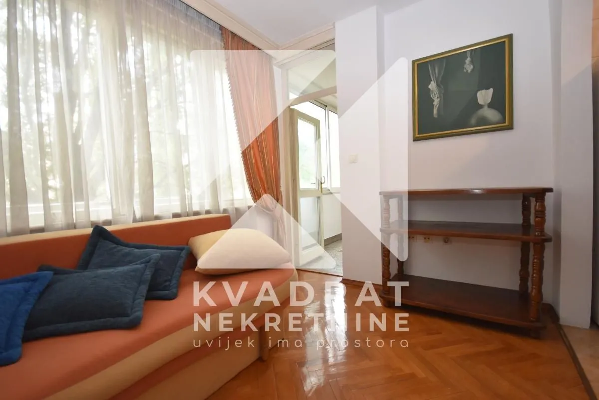Living room with sofa, wooden flooring and access to the terrace.