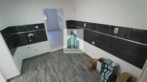 Nenameštena kuhinja sa tamnim zidnim pločicama i pogledom na susednu prostoriju. - image 6