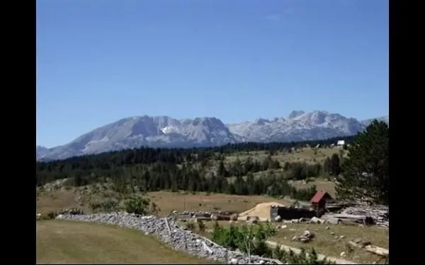 Pogled na planinske vrhove i prostrano zemljište u prirodnom okruženju.